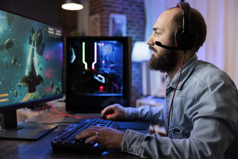 Gamer playing classic arcade space shooter videogame, shooting asteroid using lazer beams.